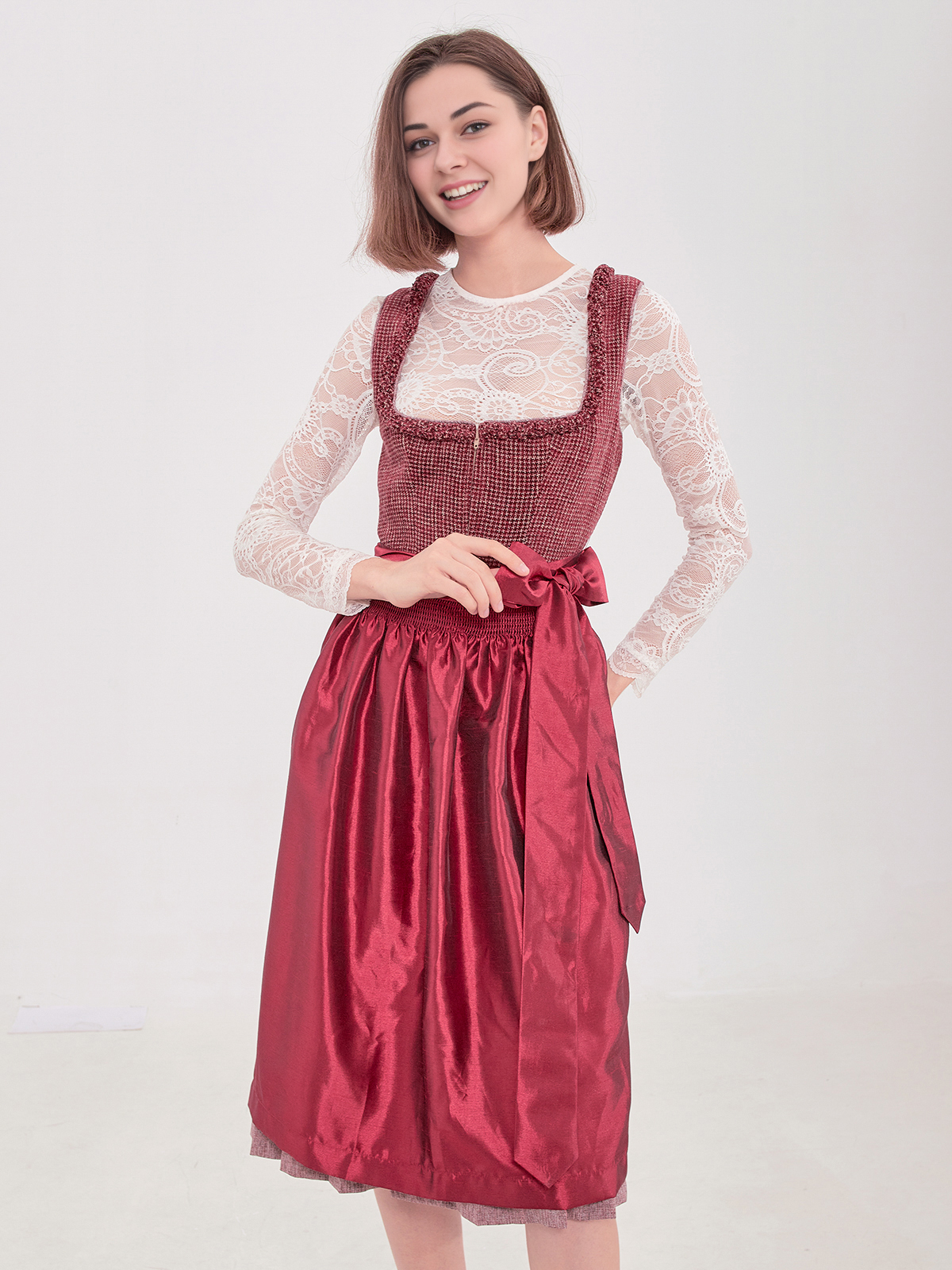 Ein rotes midi Dirndl mit schmalem Ausschnitt und weißer Schürze